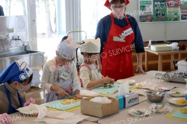 キッチンサポーター（左から１人目、同４人目）と一緒に調理に挑戦する子どもら