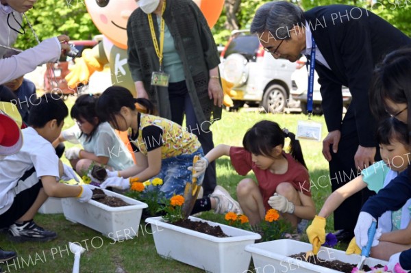 プランターに花を植える児童らと人権擁護委員ら