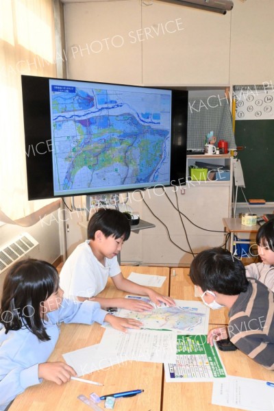 ハザードマップを確認しながら「自宅」の浸水状況や避難の必要性を話し合う児童
