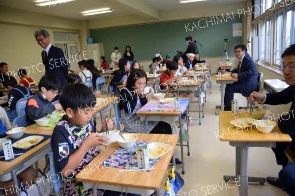 野中校長も見守る中、高嶋社長（右から２人目）と給食を食べる児童ら