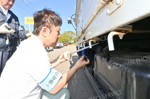 トラックから軽油を抜き取る職員