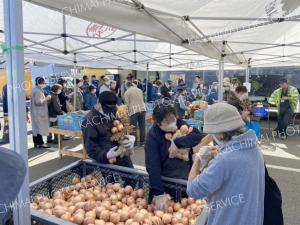 野菜の詰め放題に挑戦する来場者