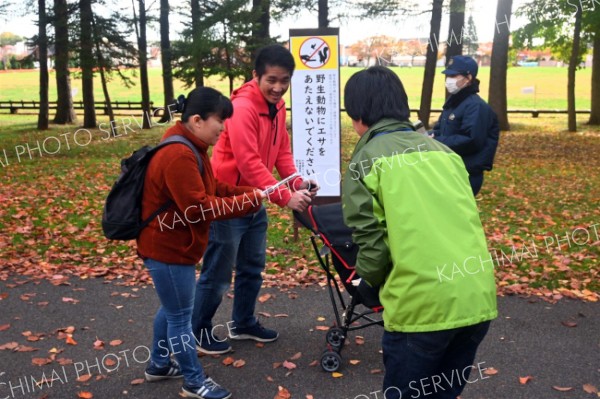 パンフレットを受け取る公園利用者）