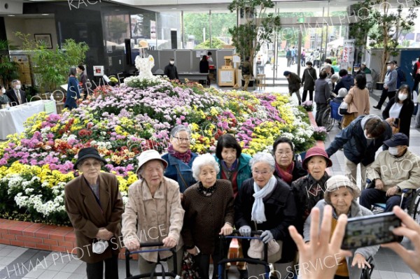 総合花壇の前で記念写真に収まる来場者（１日午前１１時ごろ、とかちプラザで。金野和彦撮影）