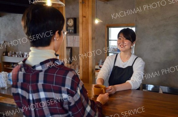 コーヒーを提供する美月店長（右）