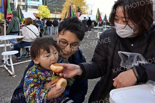 購入したあんパンを会場で食べる家族連れ（４日午前１１時半ごろ、須貝拓也撮影）