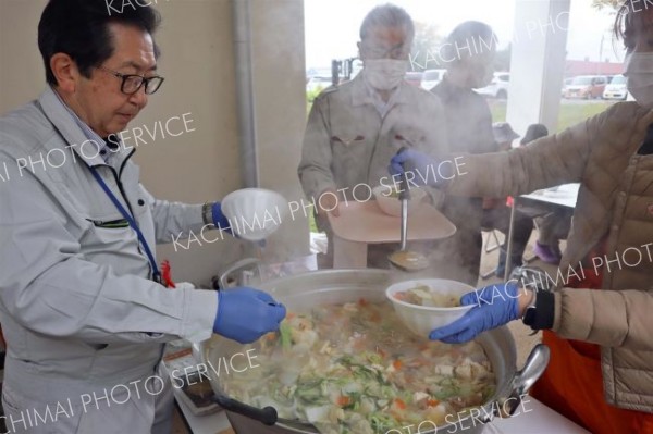 野菜がたっぷり入った豚汁をよそう町社協の石川事務局長（左）ら