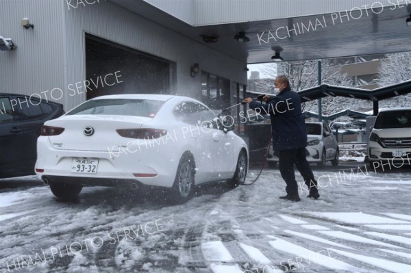 洗車機を使ってレンタカーの雪を取り除く男性（２８日午前７時４０分ごろ、ＪＲ帯広駅前）
