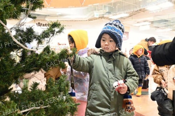 雪だるまやサンタなどのオーナメントを飾る園児ら