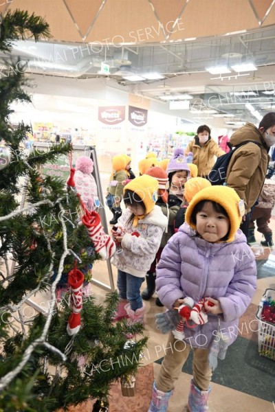 雪だるまやサンタなどのオーナメントを飾る園児ら