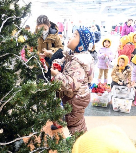 雪だるまやサンタなどのオーナメントを飾る園児ら