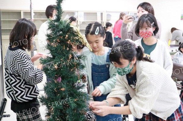 クリスマスツリーにオーナメントを飾りつける子どもたち