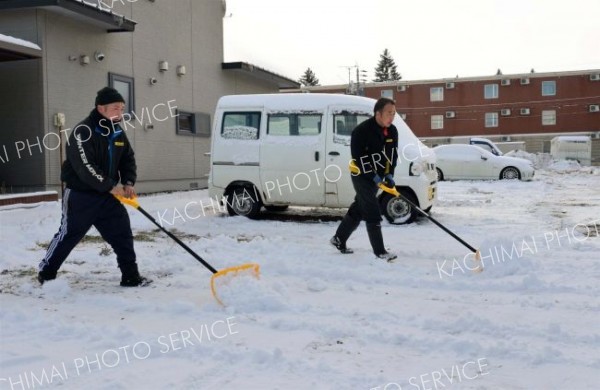 駐車場の雪を除雪する請負業者（１７日午前９時ごろ、市内西１０南１９。金野和彦撮影）