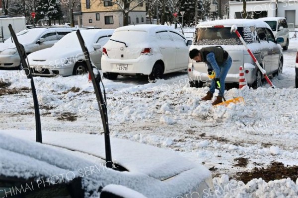 駐車場の雪を除雪する請負業者（１７日午前８時５０分ごろ、市内西１０南１９。金野和彦撮影）