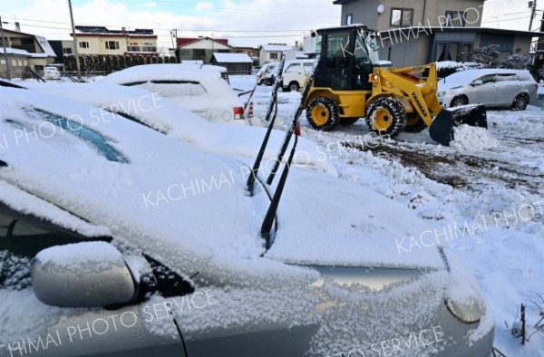 駐車場の雪を除雪する請負業者（１７日午前８時４０分ごろ、市内西１０南１９。金野和彦撮影）