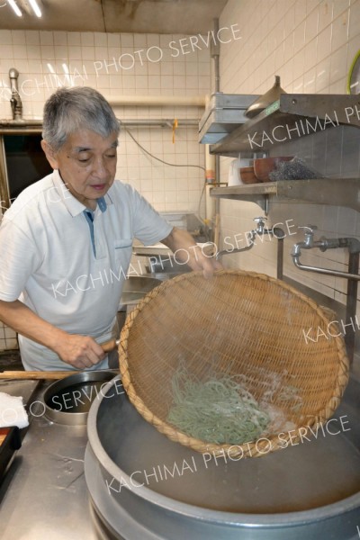 ゆで上がった「よもぎそば」をざるにあげる博さん