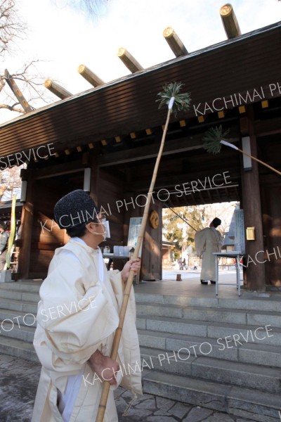 神門をすす払いする神職（２８日午前９時半ごろ、帯廣神社で。助川かおる通信員）