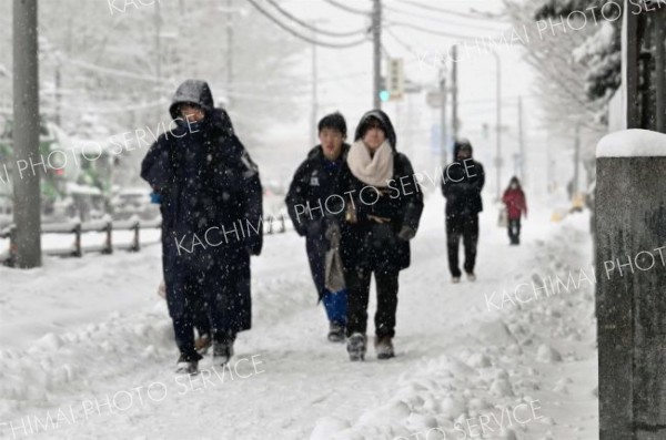 降りしきる雪の中を登校する高校生（２３日午前８時１５分ごろ、須貝拓也撮影）