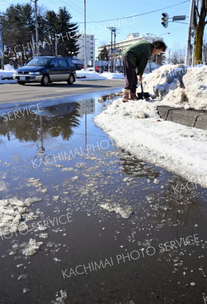 歩道の雪を崩す付近住民（３０日正午ごろ。市内西６南１９で。金野和彦撮影）