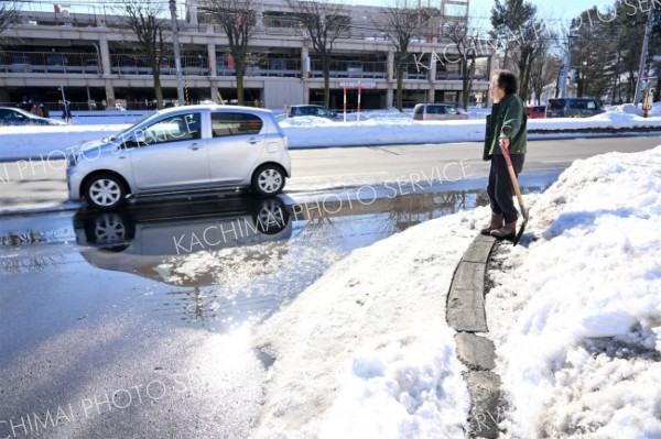 気温が上がり、車道に水たまりができた（３０日正午ごろ。市内西６南１９で。金野和彦撮影）