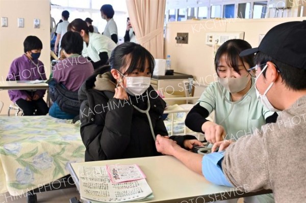 保護者の血圧を測る体験をする子ども（１７日、午前１１時ごろ、金野和彦撮影）
