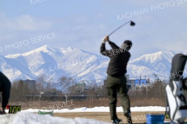 雪解けが進む練習場で、爽快にボールを飛ばすゴルファー（２３日午前１１時ごろ、札内川ゴルフ練習場で。金野和彦撮影）