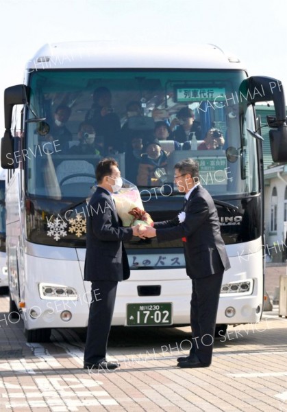 式典後、代行バスの運転士（左）に花束を贈る浜田町長（右）＝３１日、ＪＲ新得駅前で。金野和彦撮影