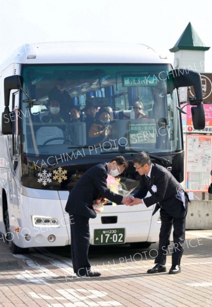 式典後、代行バスの運転士（左）に花束を贈る浜田正利新得町長（右）＝３１日、ＪＲ新得駅前で。金野和彦撮影