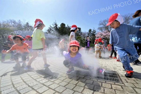 ミスト噴水で遊ぶ園児たち（２６日、午前１０時１５分ごろ、音更町役場前で。金野和彦撮影）