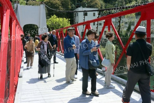 国内最古の近代吊り橋「美濃橋」を見学する訪問団。観光客の大勢訪れていた