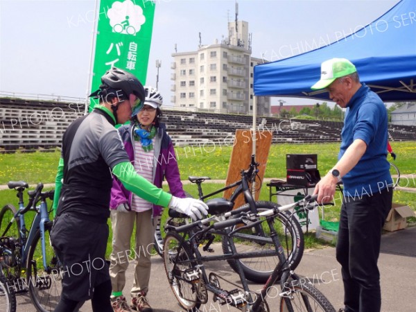 ２人乗り用自転車の乗り方の説明を受け試乗する市民ら