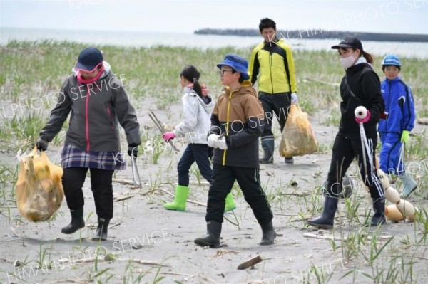 海岸のごみを拾い集める児童ら