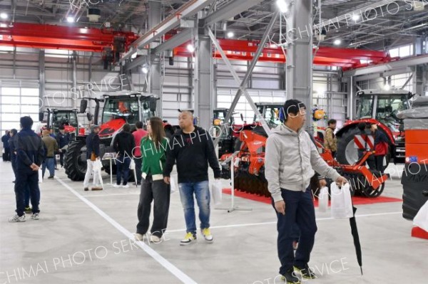 新型トラクターなど見て楽しむ来場者ら