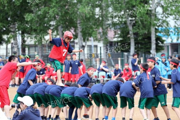 慎重に背中を渡る生徒（１日、帯広第五中学校。長尾悦郎通信員撮影）