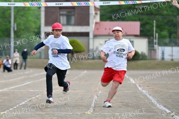 １００メートル走で接戦を演じる児童