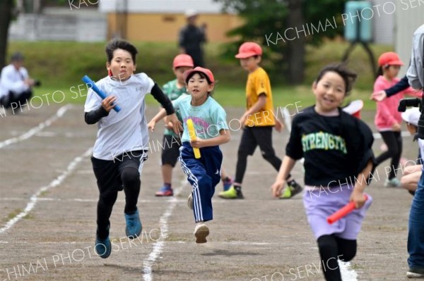 ３・４年生のリレーで力いっぱい走る子どもたち（８日、更別小学校。金野和彦撮影）