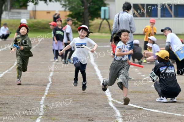 ３・４年生のリレーで力いっぱい走る子どもたち（８日、更別小学校。金野和彦撮影）