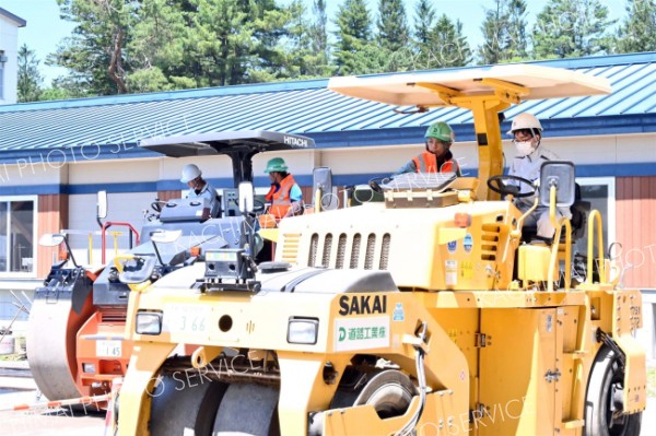 道路工事で使用する車両の操縦を体験する生徒