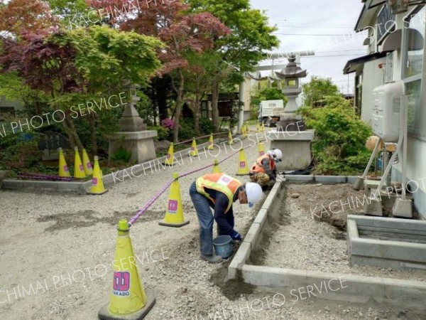 参道に砂利を敷き詰める高堂建設職員ら（高堂建設提供）