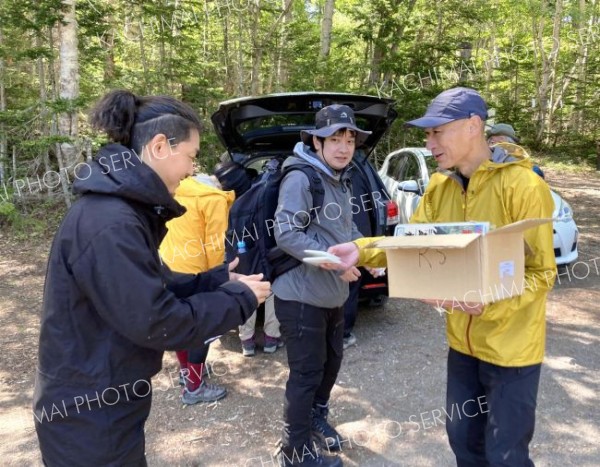 山岳遭難防止などの啓発資料を手渡す佐藤署長（右）