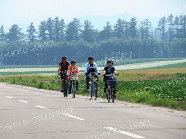 中札内の風景を楽しみながら自転車を走らせる参加者とガイド