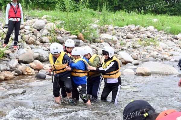 ６人一組になって腕を組む「浅瀬横断法」で川を渡った児童