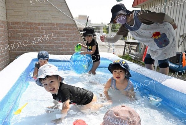 ２歳児クラスでは日よけの下にプールを設置。自然と笑顔がこぼれる子どもたち（松葉保育所）