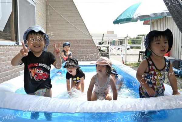 ２歳児クラスでは日よけの下にプールを設置。自然と笑顔がこぼれる子どもたち。