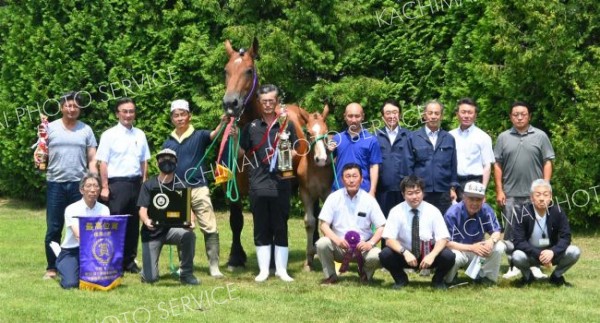 最高位となった「マオノクイーン」と関係者。馬の右でトロフィーを持っている