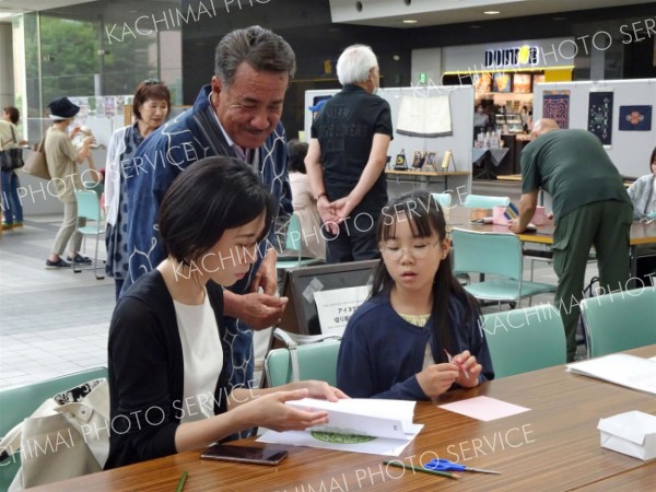 切り絵体験の参加者と交流する笹村会長