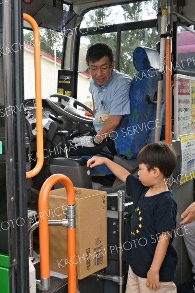 降車する際に折り紙でで来た硬貨を運賃箱に入れる子ども