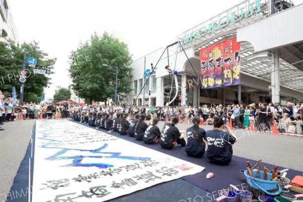 日高山脈をイメージした大型トラスで華麗な技を披露したエアリアルアーティストの長すみ絵さんの演技に歓声を上げる来場者ら（平栗玲香通信員撮影）