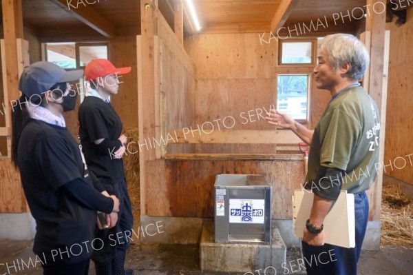 稲葉園長から「馬ふれあい舎」の特徴の説明を受ける参加者（１７日午前１０時２５分ごろ）