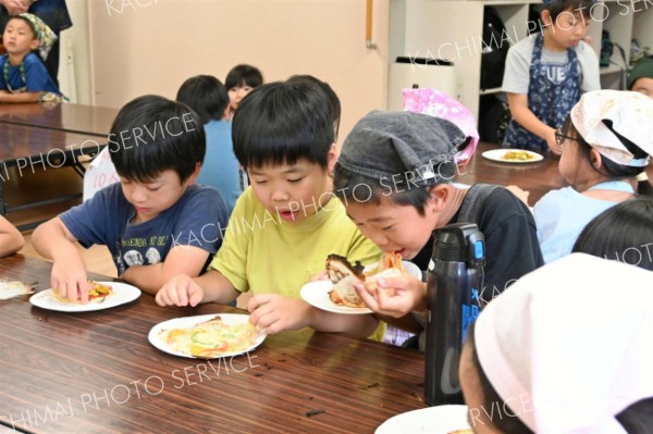 石窯で焼いた熱々のピザを味わう子どもたち